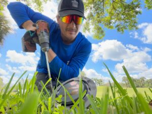 Wise House Pest Control technician installing subterranean termite bait stations in Jupiter Florida