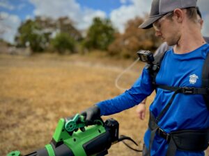 Technician performing outdoor pest control treatment in South Florida yard