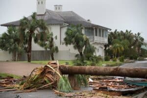Hurricane storm damage with fallen trees and debris near a South Florida home