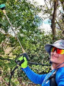 Mosquito control technician treating landscaping in a South Florida yard