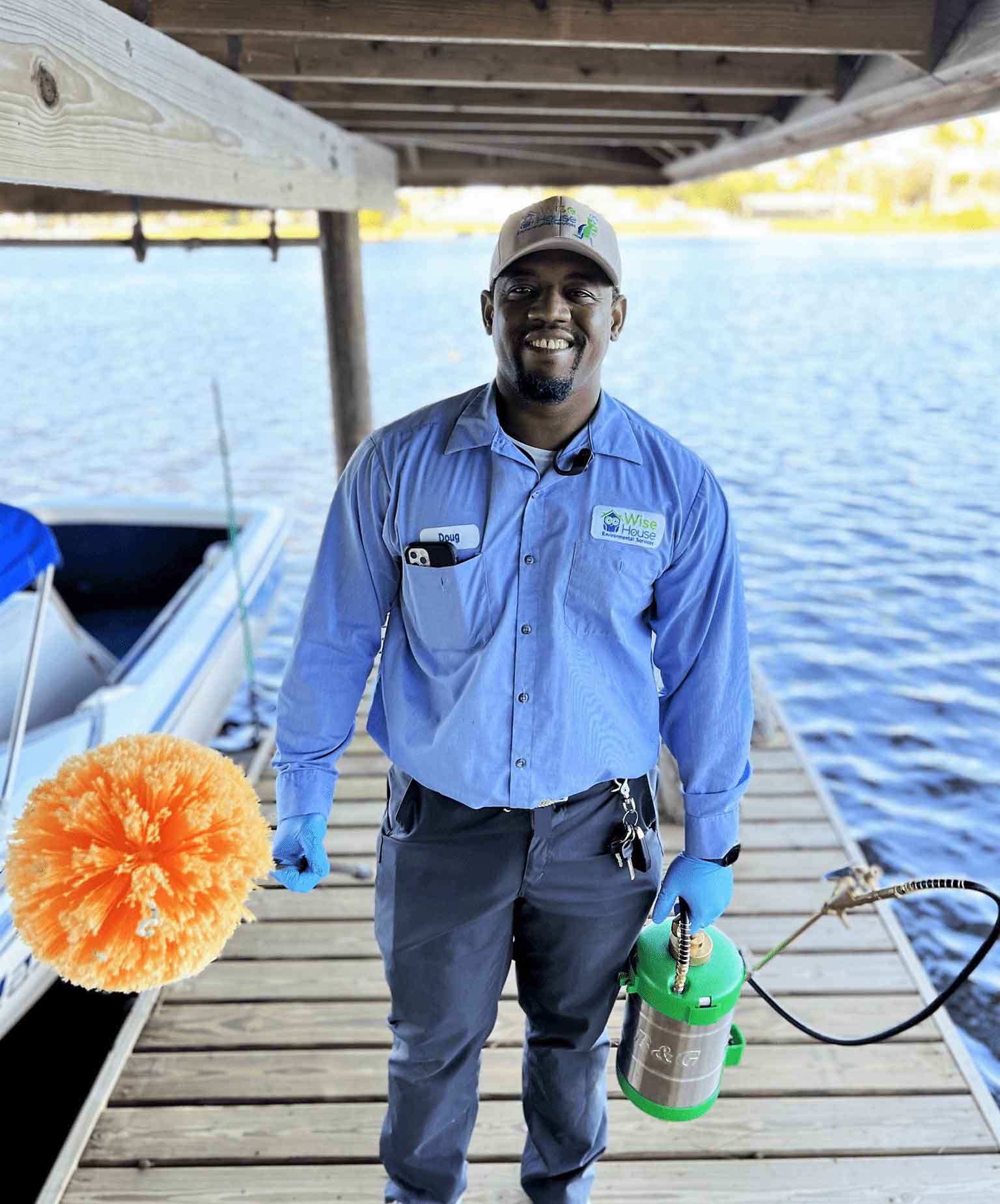 Wise House Pest Control technician treating a waterfront dock in South Florida