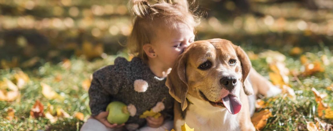Child with her dog outdoors, illustrating the household safety considerations behind pet-friendly pest control